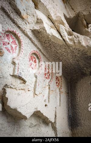 A row of red Maltese crosses decorates the wall of an early Christian church in Goreme Open Air Museum (UNESCO heritage site), Cappadocia, Turkey Stock Photo