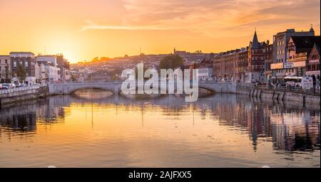 Cork, Ireland: scenic sunset view of St Patrick's Bridge at dusk, River Lee, building reflections on water, twilight, urban romantic cityscape Stock Photo