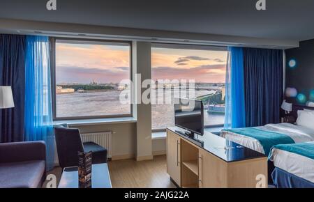 Saint Petersburg, Russia: Luxury modern interiors of hotel suite, floor to ceiling windows, view over Neva river and Saint Petersburg cityscape Stock Photo