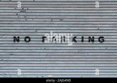 closed shutter on store or shop front saying no parking Stock Photo