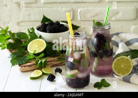 Homemade refreshing citrus lemonade mojito blackberry with  ingredients for making on wooden table. Stock Photo