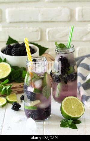 Homemade refreshing citrus lemonade mojito blackberry with  ingredients for making on wooden table. Free space for your text. Stock Photo
