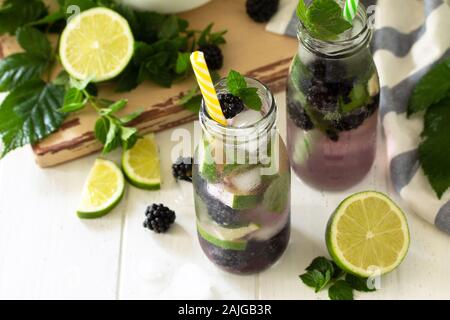 Homemade refreshing citrus lemonade mojito blackberry with  ingredients for making on wooden table. Free space for your text. Stock Photo