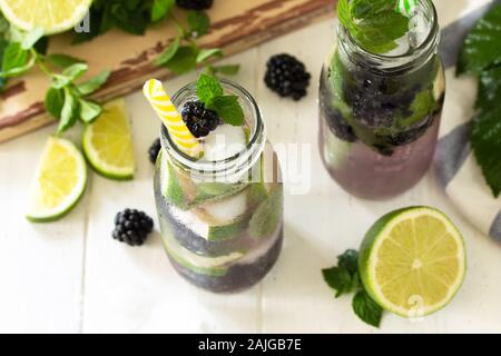 Homemade refreshing citrus lemonade mojito blackberry with  ingredients for making on wooden table. Stock Photo