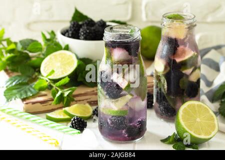 Homemade refreshing citrus lemonade mojito blackberry with  ingredients for making on wooden table. Stock Photo
