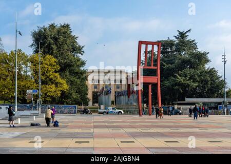 Geneva, Switzerland - April 15, 2019:  Broken Chair monument near United Nations palace with tourists - image Stock Photo