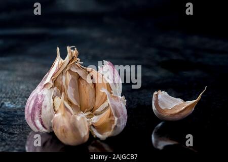 Whole garlic bulb close-up isolated on black background. Stock Photo