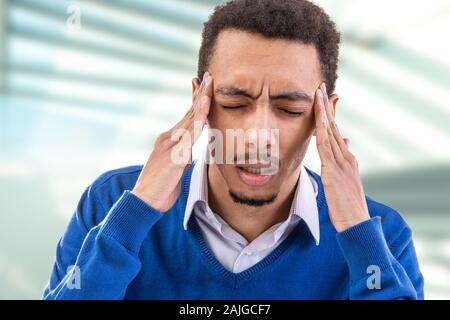 Young man touching temples trying to focus or feeling headache. Stock Photo