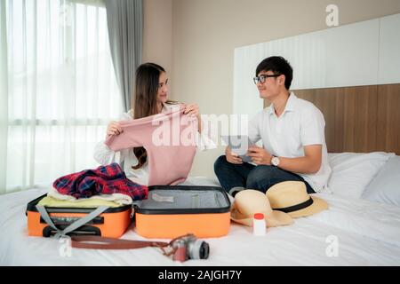 Happiness Asian couple traveler packing suitcases preparing for travel vacation together and looking fun when they preparing to journey. Asian backpac Stock Photo