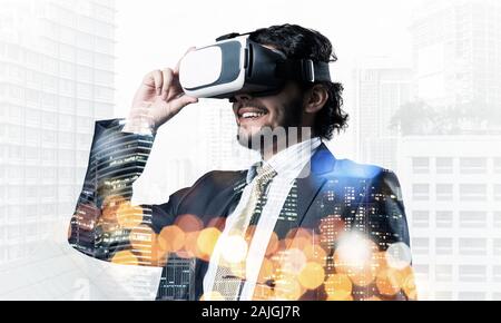 Double exposure of businessman in virtual helmet against cityscape background Stock Photo