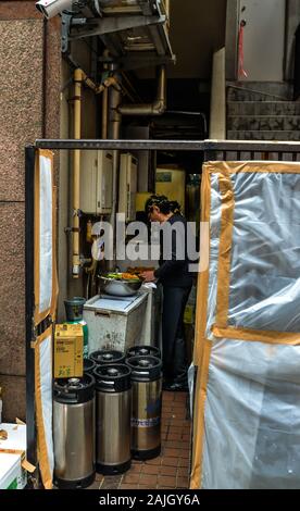 Tokyo/Japan - 10/25/19 - A kitchen opening out into the street in Shibuya, the chaotic area of Tokyo known for its many small bars and restaurants and Stock Photo