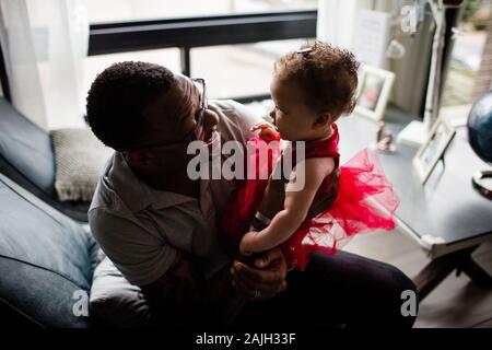 African American Dad Smiling at Biracial Daughter Stock Photo