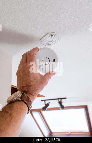 Man installing home security alarm system on white wall indoors ...