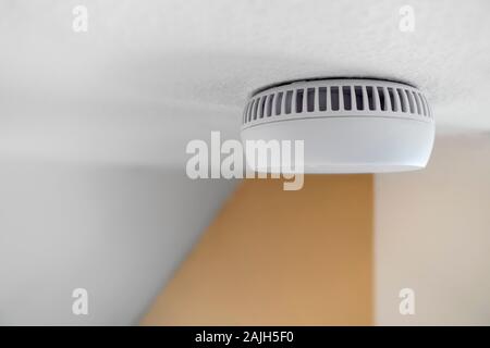 Domestic smoke alarm / battery powered smoke detector on the ceiling in the hall at home Stock Photo