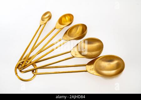 Brass measuring spoons non metric on white background Stock Photo
