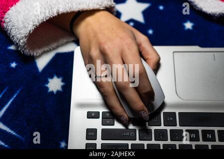 Detail of woman hand using a white mouse over a laptop keyboard. Business concept, close up Stock Photo