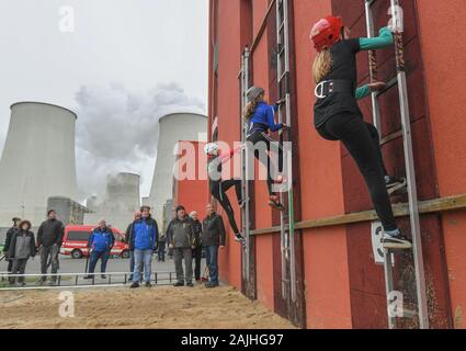 04 January 2020, Brandenburg, Jänschwalde: Junior members of volunteer fire brigades take part in the competition in hook ladder climbing on the training tower of the works fire brigade of the lignite-fired power station of Lausitz Energie Bergbau AG (LEAG). Around 75 firefighters from Eastern Germany and the Czech Republic took part in the competition in hook ladder climbing in the Lausitz region. On the grounds of the fire station at Jänschwalde power station, the participants fought over who was the fastest to climb a building. The winner receives the traditional New Year's Cup. The 'New Ye Stock Photo