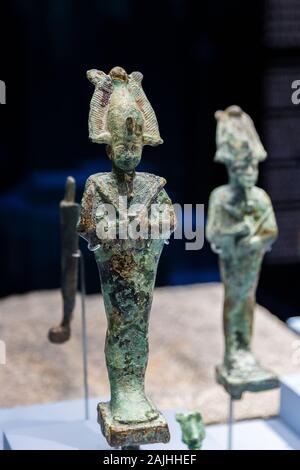 Photo taken during the opening visit of the exhibition “Osiris, Egypt's Sunken Mysteries”. Statuettes of the god Osiris. Stock Photo