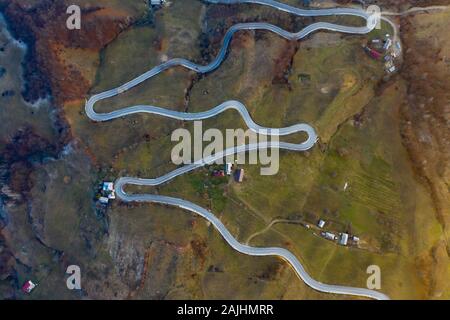 M shaped curving road in autumn landscape - aerial view. Stock Photo