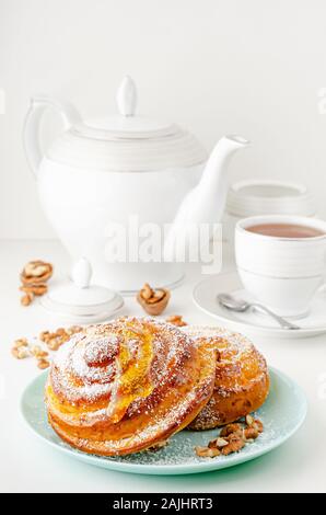 Homemade bakery. Sweet buns with honey, walnuts and grated coconut on white background. Breakfast table concept. Stock Photo