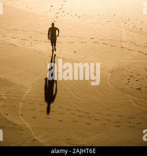 Top view of a surfer running on the beach Stock Photo