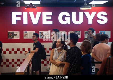 03.01.2020, Singapore, Republic of Singapore, Asia - Customers at the city's first Five Guys burgers and fries branch of the America fast food chain. Stock Photo