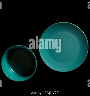 Colored plates of different shapes stand on a black background. Stock Photo