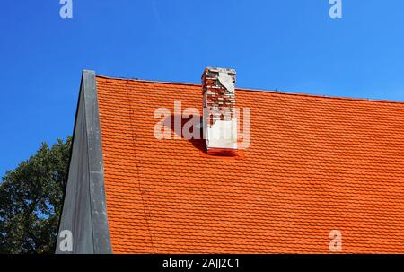 Bright orange roof with old brick trumpet on the site of Red stone castle, Slovakia, Europe Stock Photo