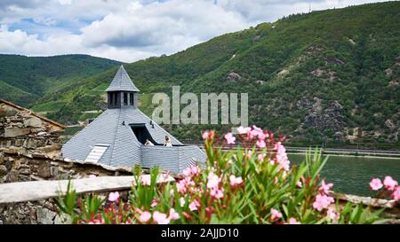 Two female wedding guests enjoy some time on a balcony overlooking the majestic Rhine River from high up in Reichenstein Castle grounds. Stock Photo