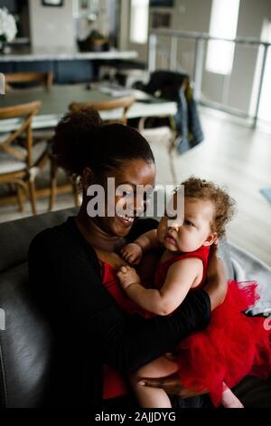 African American Sister Holding Mixed Race Baby Sister Stock Photo