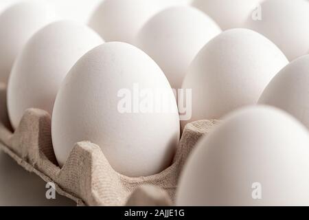 Detail of white chicken eggs in a paper tray. Stock Photo