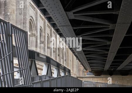 Interesting architectural structures with converging lines of steel and stone from the underside of an elevated urban train trestle in Berlin, Germany. Stock Photo