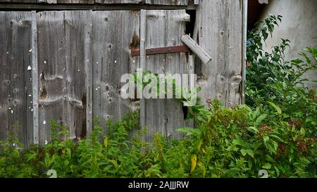Old weathered barn with single rustic door in rural Bavaria. Stock Photo
