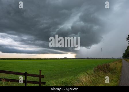 Strong thunderstorm with hail shaft over the green dutch countryside Stock Photo