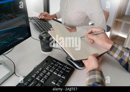 Pensive programmer working on desktop pc programming code technologies or website design at office Software Development Company Stock Photo