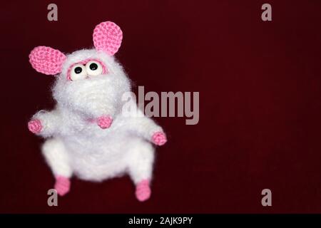 White knitted toy rat on red cloth background, New Year card. Chinese Year of Rat, Zodiac symbol 2020 Stock Photo