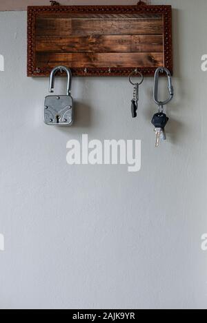 Keys hanging on a wooden wall keyholder Stock Photo
