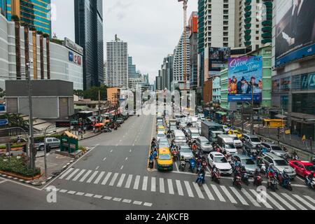 Drivers and motorbike/scooter riders wait at the busy Asok intersection, in Bangkok, Thailand Stock Photo