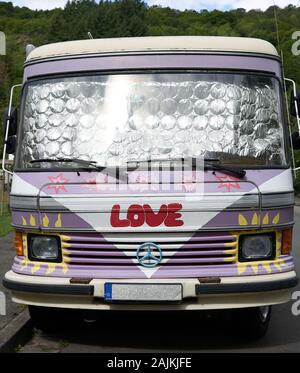 Cool Love Bug.  Old Mercedes camper van with hippie like paint job including the word Love emblazoned by the front grill work. Stock Photo