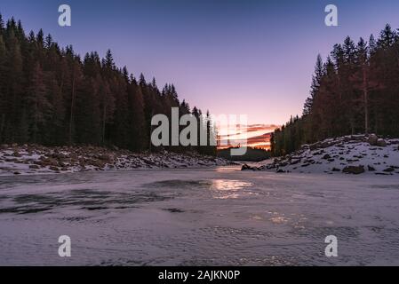 Winter nature. Snowy icy lake shore in mountains. Scenic winter landscape. Beautiful ice mountain lake Stock Photo