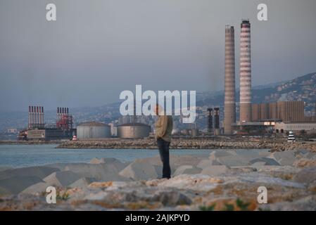 *** STRICTLY NO SALES TO FRENCH MEDIA OR PUBLISHERS *** November 18, 2019 - Beirut, Lebanon: A man walks in the foreground of the Zouk power station north of Beirut. Lebanon faces regular power shortage despite the set-up of Turkish-owned floating power plants. Stock Photo