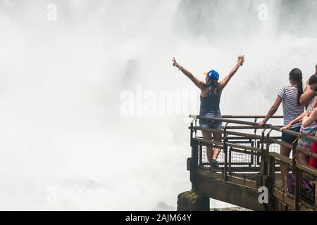 Puerto Iguazu, Argentina - Circa November 2019: Young woman posing for pictures by Salto Bossetti, one of the waterfalls at the Iguazu National Park Stock Photo