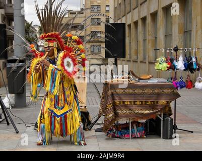 Indigenous street performer playing flute and selling CD's and souvenirs on Carrera 7 near Plaza de Bolivar, La Candelaria, Bogota, Colombia Stock Photo