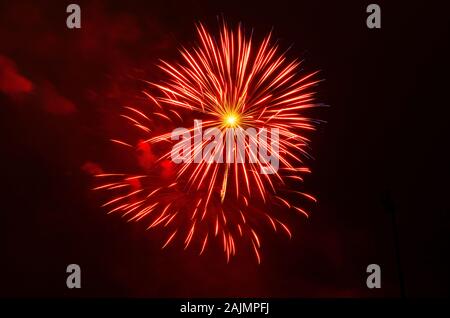 vibrant red fireworks display against black sky during holiday celebration Stock Photo