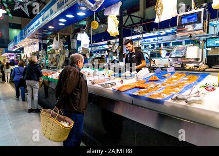 Elderly man holding a basket, shopping at a fish stall in Mercat de l'Olivar, Palma, Mallorca, Spain Stock Photo