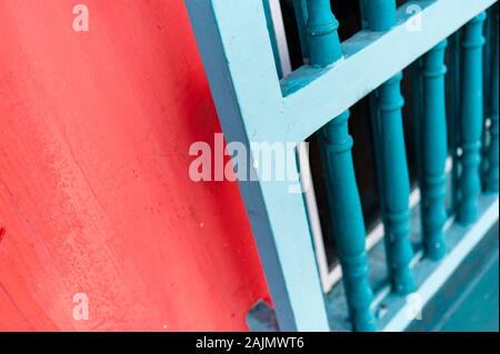 Colorful alley with wooden windows in red wall with shadows Stock Photo