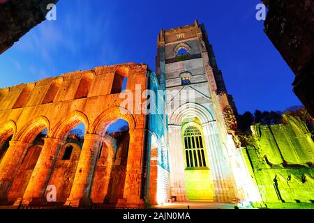 Fountains Abbey Tower at night, during Christmas coloured illuminations Stock Photo
