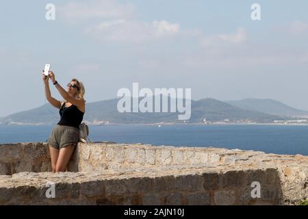 Female tourist takes a selfie on the top of Eivissa Castle in Eivissa (Ibiza Town) Stock Photo