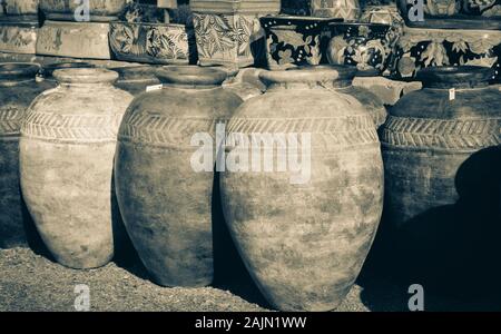 An assortment of patinas on primitive style pots and assorted planters on display in Mexican designs in the artisan town of Tubac, AZ, USA, in sepia Stock Photo