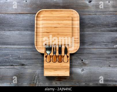 Overhead view of bamboo food server with various utensils on rustic wooden table Stock Photo